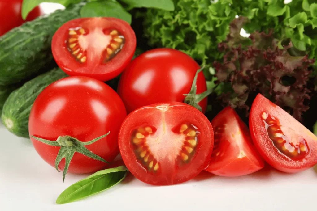 Fresh tomatoes, cucumbers, and leafy greens harvested from a square foot garden in a small space.